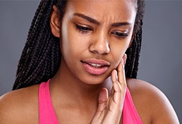 Woman with toothache holding cheek