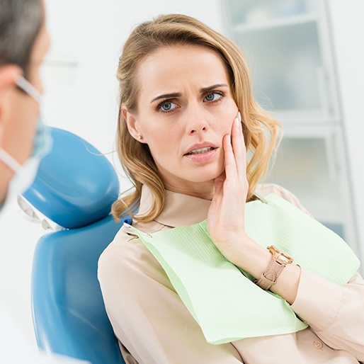 Woman holding cheek in pain