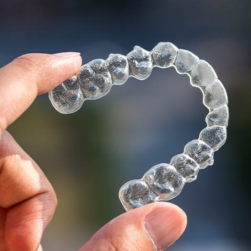 Hand holding an Invisalign tray