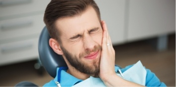 Man holding jaw in pain