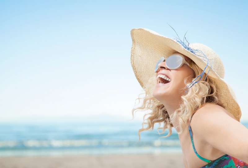 woman smiling at the beach after visiting dentist in Columbus