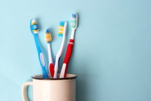 Assorted toothbrushes in a cup.
