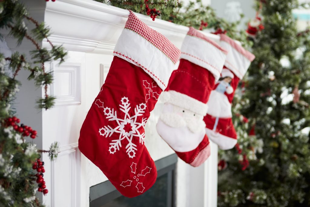 Red and white stockings hung over a white fireplace