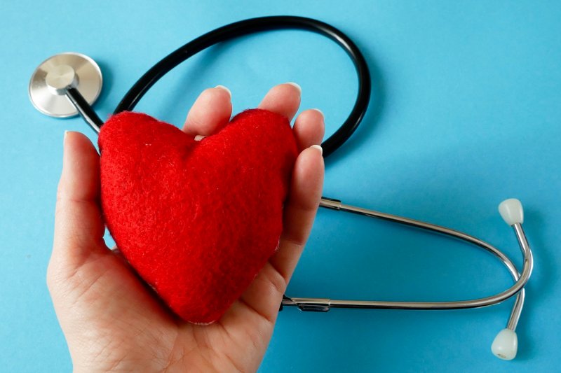 A hand holding a fuzzy felt heart